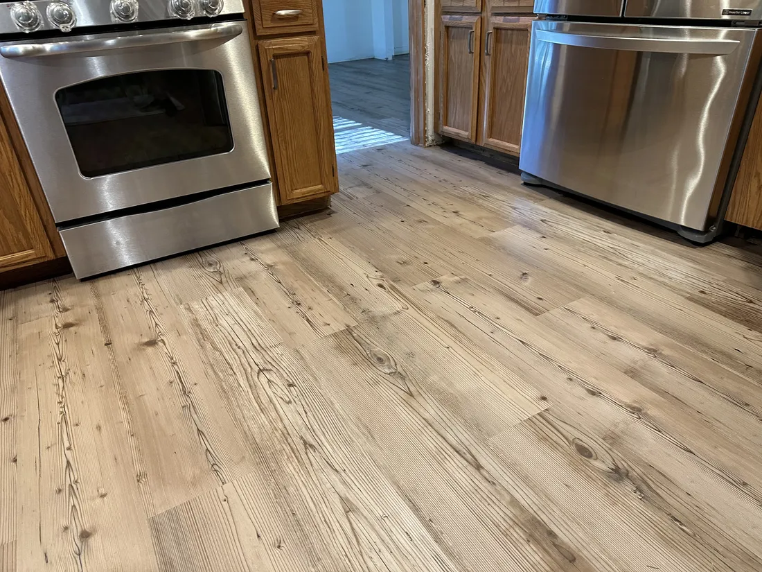 New wood-look plank flooring in a kitchen, installed over a freshly leveled subfloor