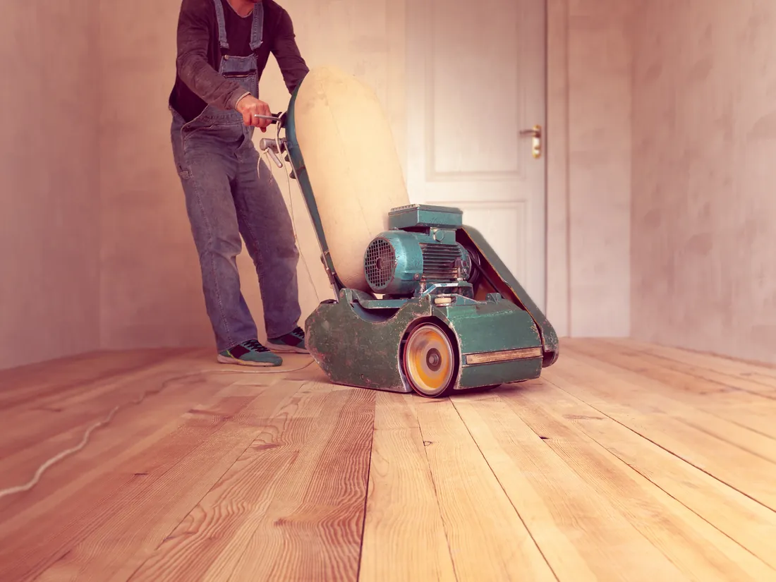Hardwood floor being sanded to bare wood before a new finish