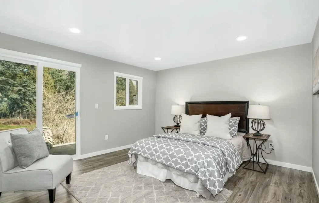 Bedroom with new plank flooring, fresh paint and a sliding door