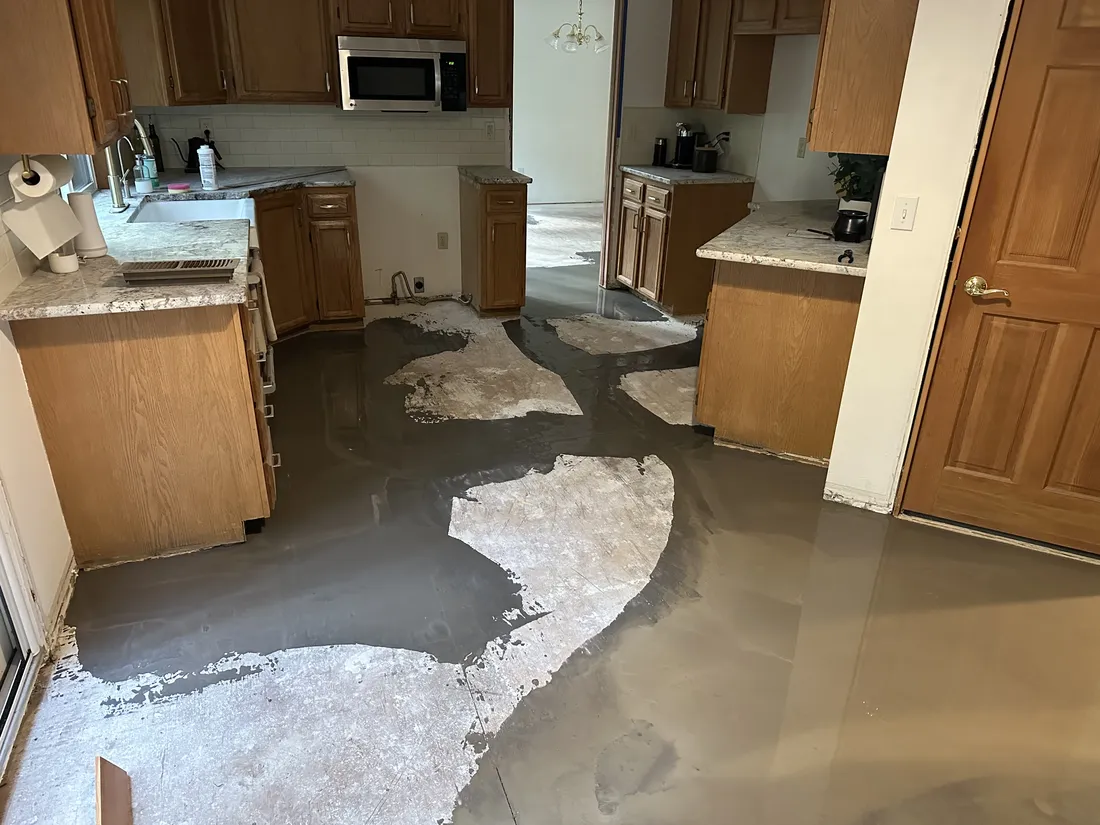 Self-leveling compound poured over a repaired kitchen subfloor