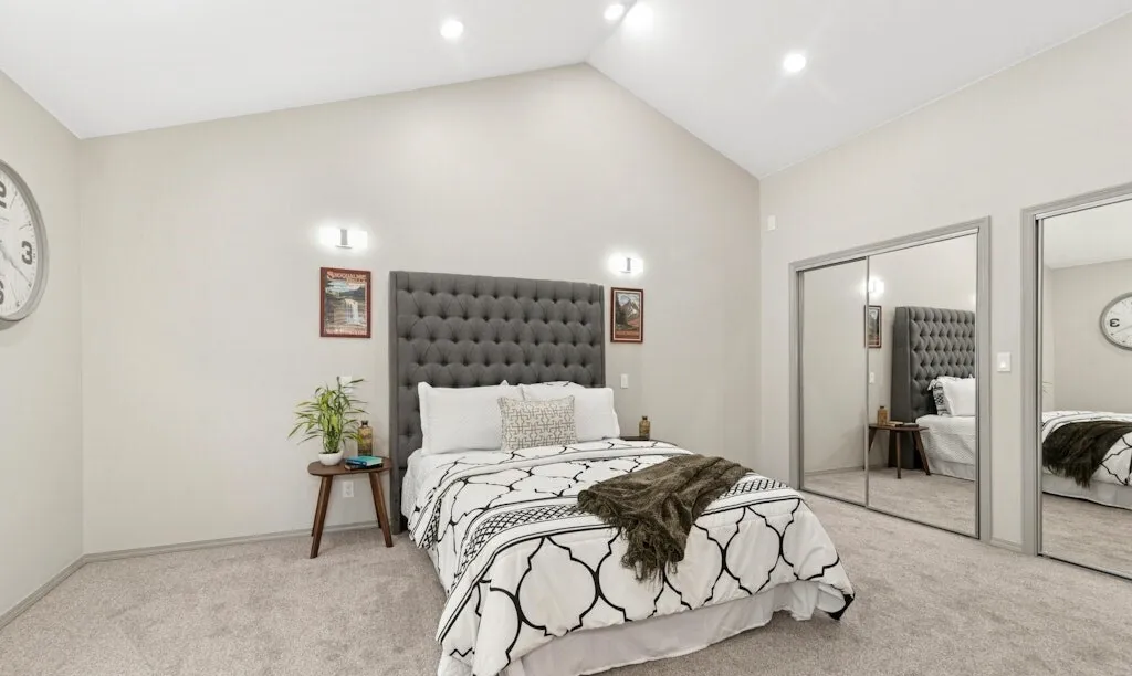Bedroom with new carpet, vaulted ceiling and mirrored closet doors