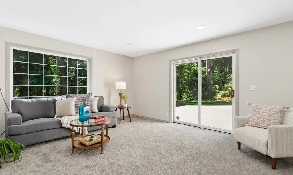 Remodeled living room with new carpet, fresh paint and a sliding door to the patio